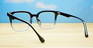 Square black to clear fade blue blocker glasses with silver details and pins