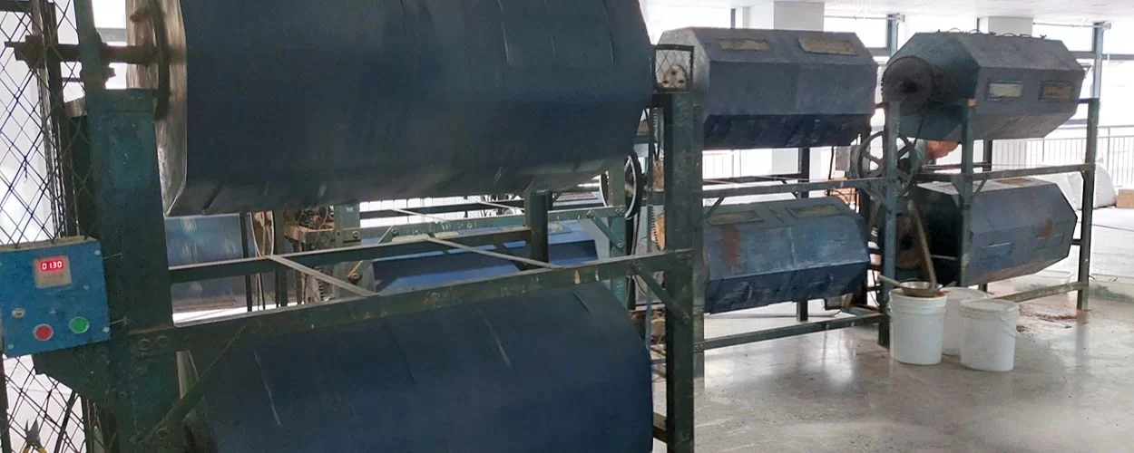 Rotating polishing barrels used to smooth sunglasses frames at an eyewear factory
