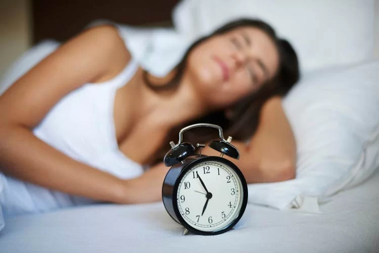 woman sleeping with alarm clock set - iPOP NZ